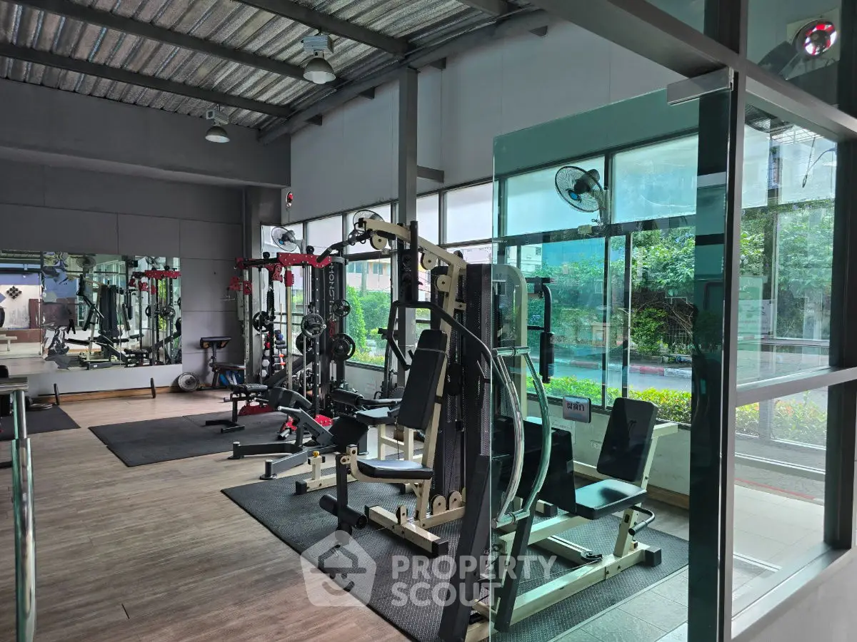 Modern gym with state-of-the-art equipment and large windows for natural light.