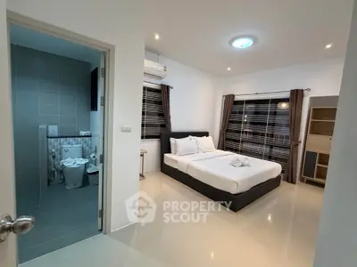 Modern bedroom with ensuite bathroom, featuring sleek design and ample natural light.