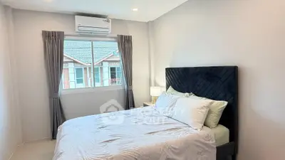 Cozy bedroom with modern decor and large window offering natural light