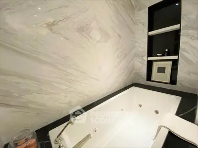 Luxurious bathroom with elegant marble walls and a spacious bathtub, perfect for relaxation.