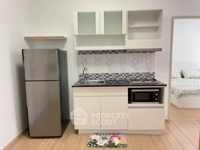 Compact kitchen with modern appliances and cozy decor in a stylish apartment.