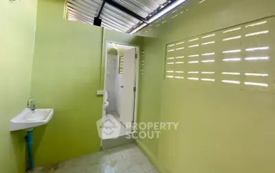 Simple bathroom with green walls and basic fixtures