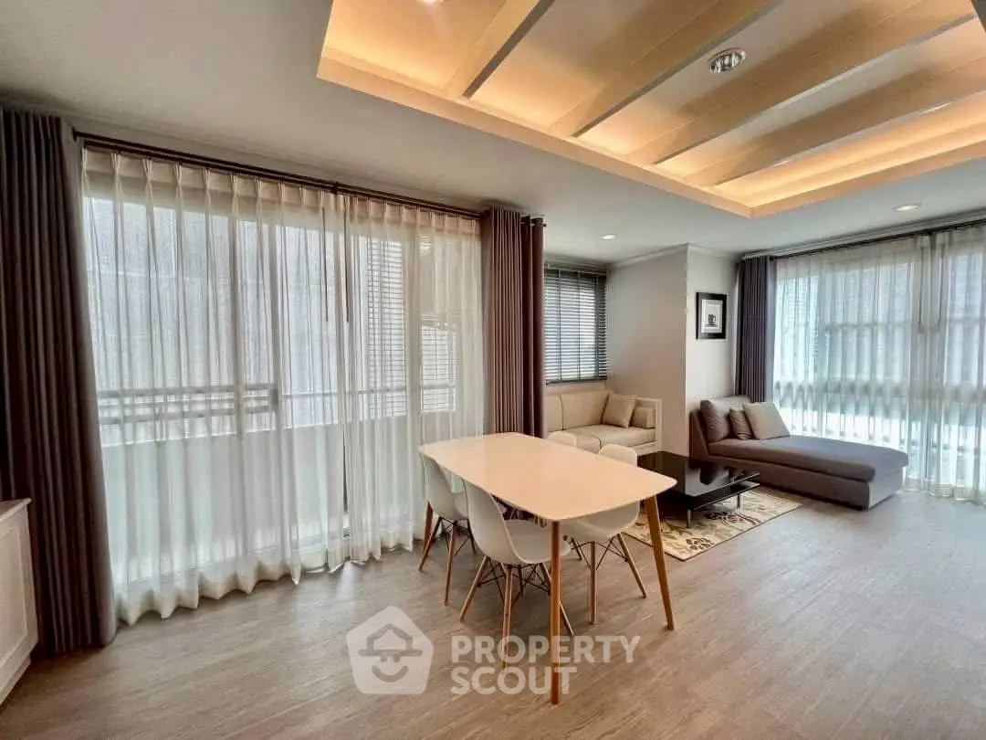 Spacious modern living room with elegant dining area and large windows for natural light.