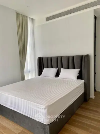 Spacious modern bedroom with elegant bed and natural light