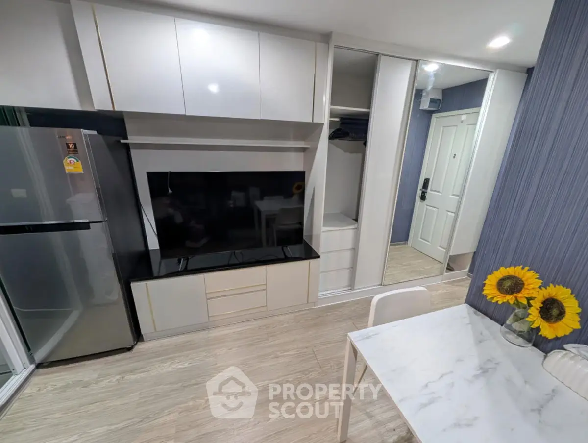Modern apartment interior with sleek kitchen and dining area featuring sunflowers on the table.