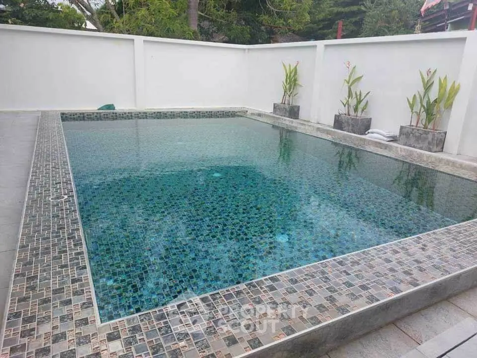 Luxurious private pool with elegant tile design in serene outdoor setting.