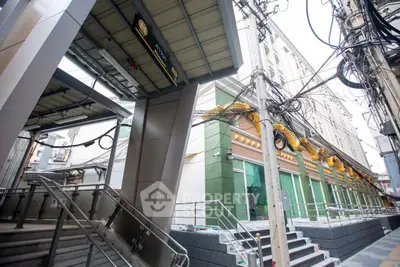 Modern urban building exterior with sleek design and convenient access to public transportation.