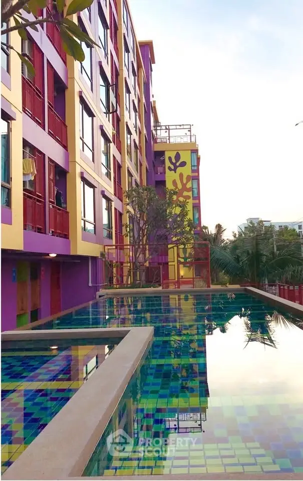 Vibrant modern apartment building with colorful facade and inviting outdoor pool area.
