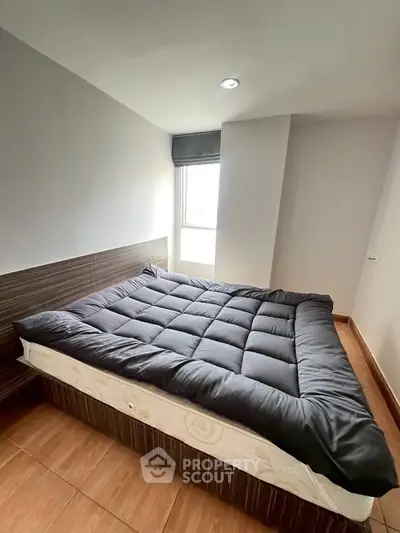 Spacious bedroom with modern decor and large window for natural light