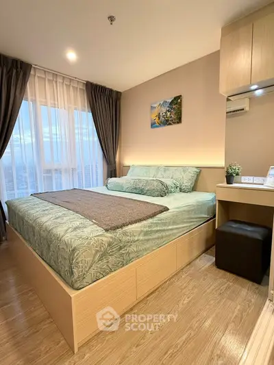 Cozy bedroom with large window and modern decor in high-rise apartment.