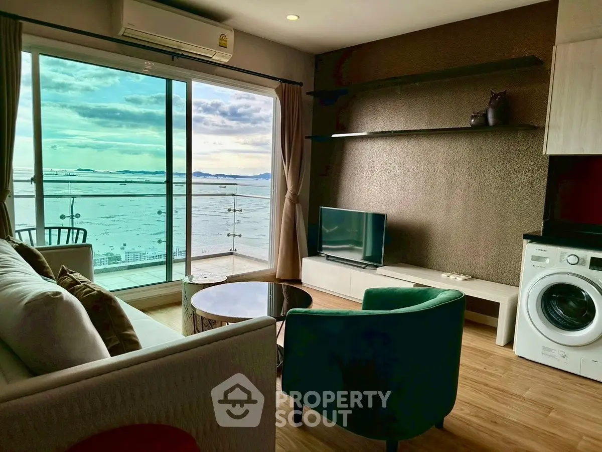 Modern living room with stunning sea view, featuring stylish furniture and in-unit washing machine.