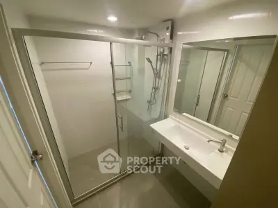 Modern bathroom with glass shower enclosure and sleek sink design