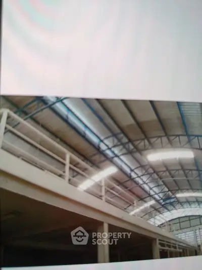 Spacious industrial warehouse with high ceilings and ample natural light, perfect for large-scale operations.