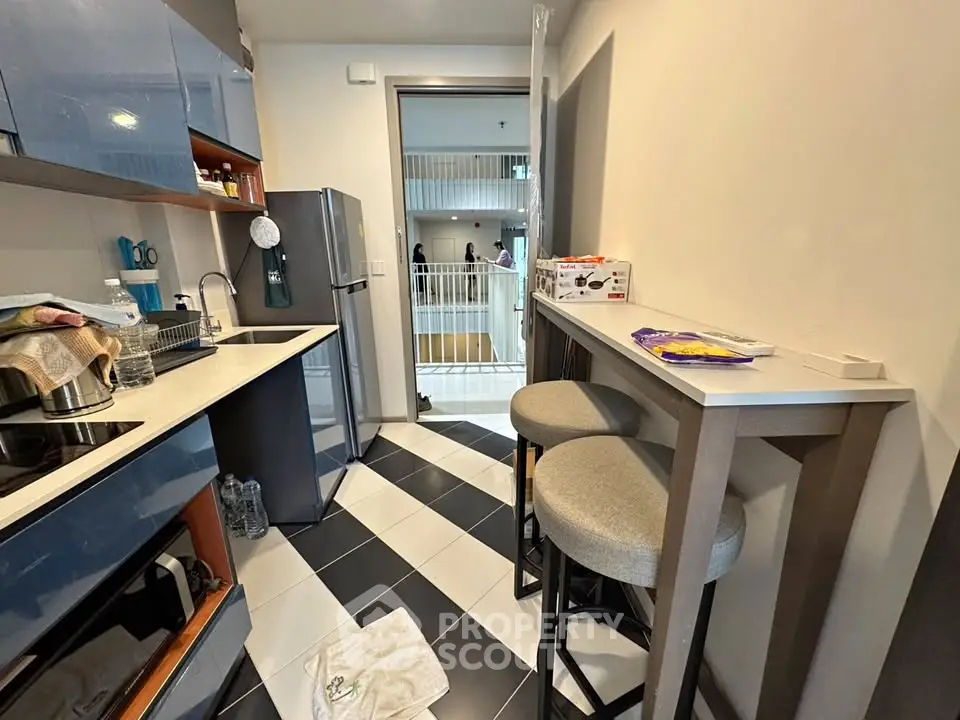 Modern compact kitchen with sleek cabinets and breakfast bar in urban apartment