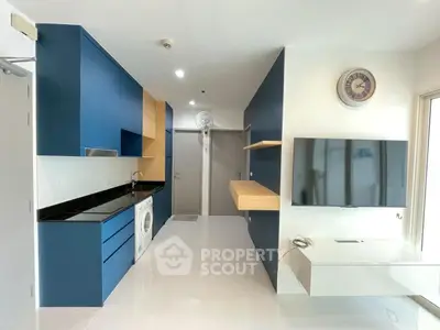 Modern kitchen with blue cabinets and built-in appliances in sleek apartment