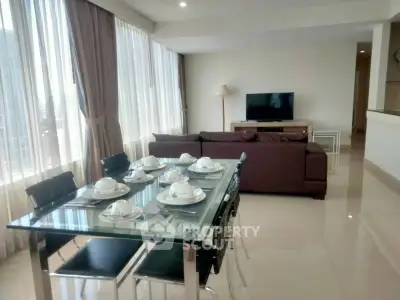 Spacious living room with elegant dining area and modern decor in a bright apartment.