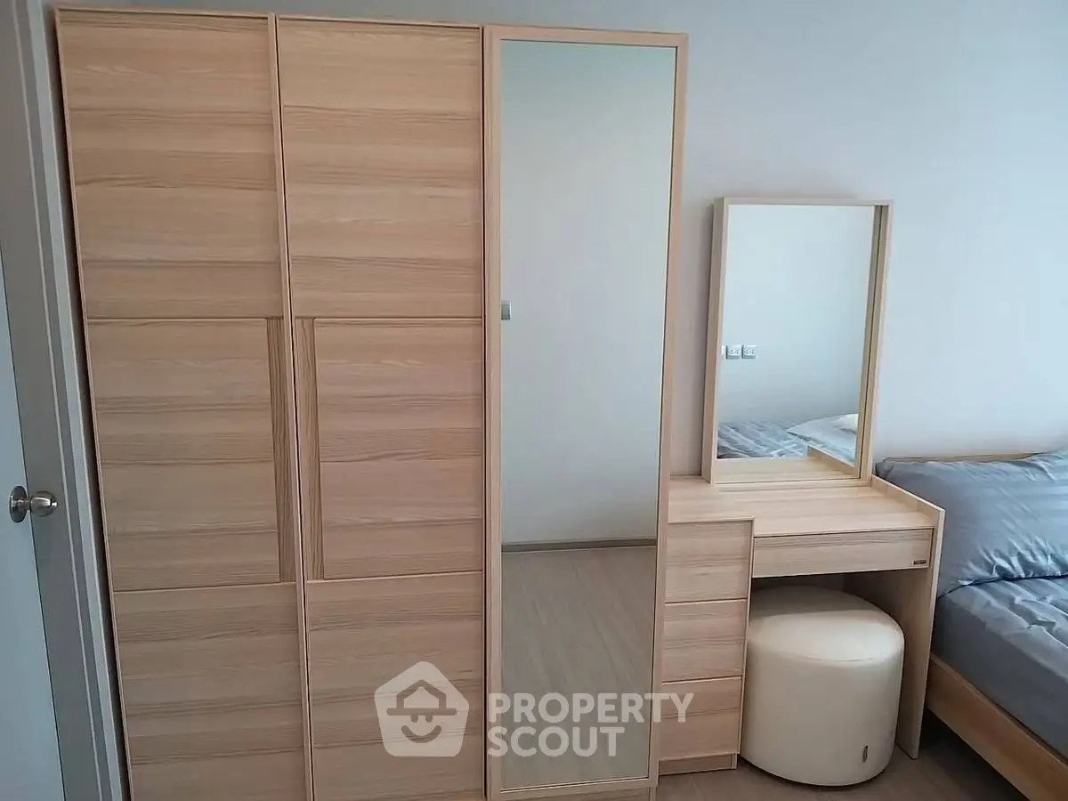Modern bedroom with sleek wooden wardrobe and stylish vanity set.