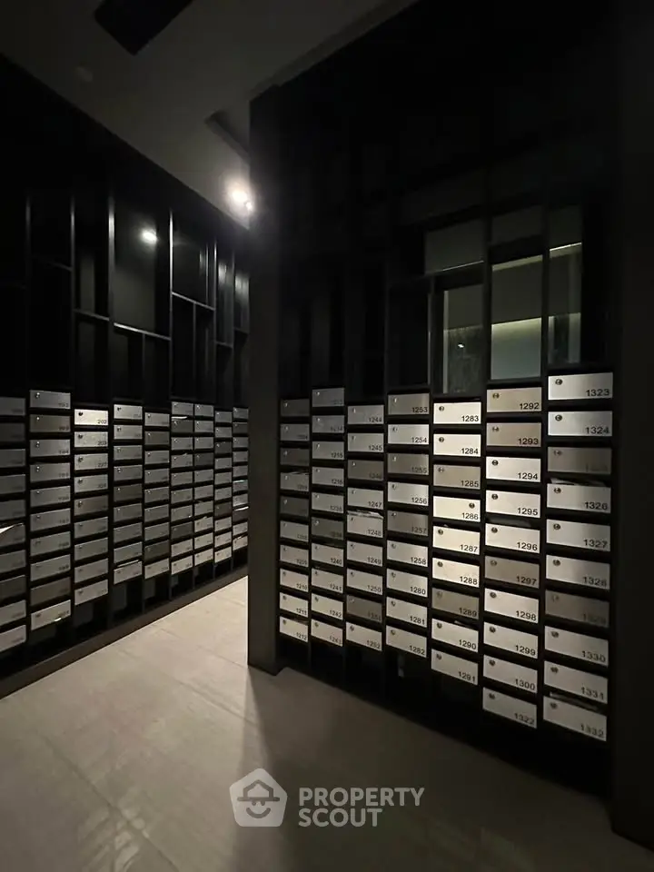 Modern apartment building mailroom with sleek black and silver mailboxes