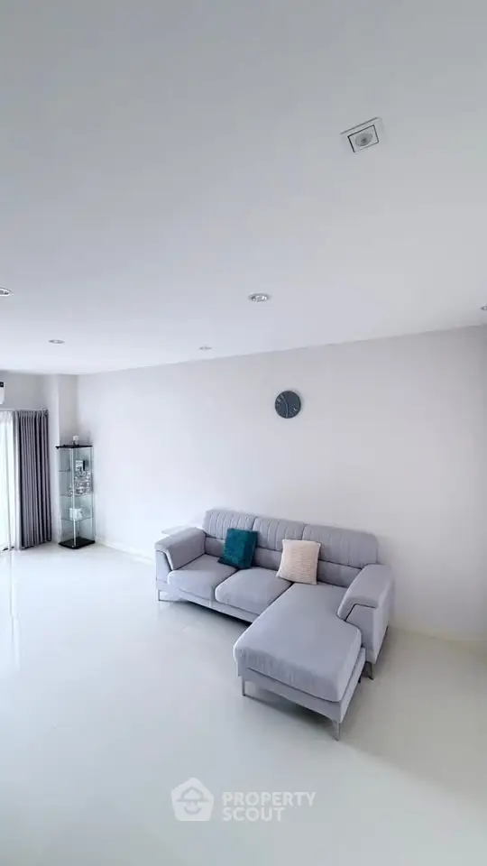 Spacious modern living room with elegant gray sofa and minimalist decor.