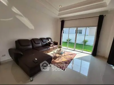 Spacious living room with modern leather sofa and garden view