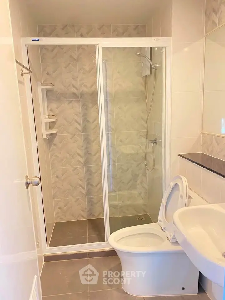 Modern bathroom with glass shower enclosure and sleek fixtures