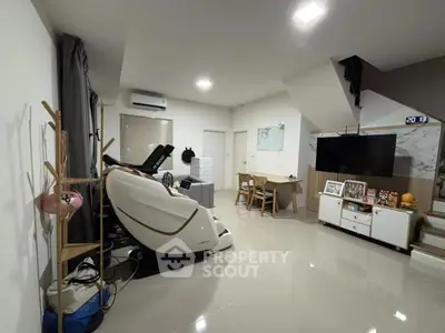 Spacious living room with modern decor and massage chair, ideal for relaxation and entertainment.