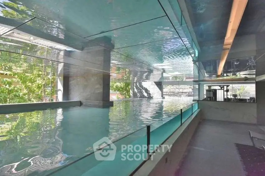 Luxurious indoor pool with modern design and glass walls offering a serene ambiance.