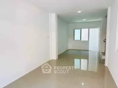 Spacious empty room with glossy tile flooring and white walls, perfect for customization.