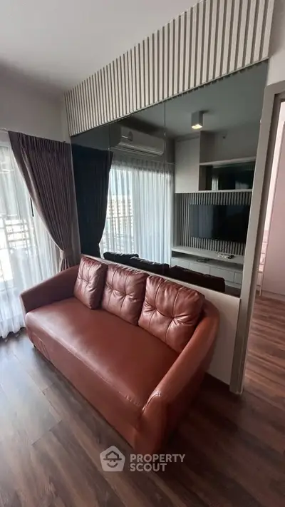 Modern living room with stylish leather sofa and large window with curtains