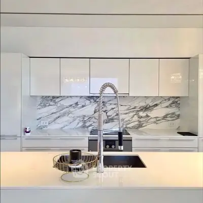 Luxurious modern kitchen with sleek white cabinets and marble backsplash