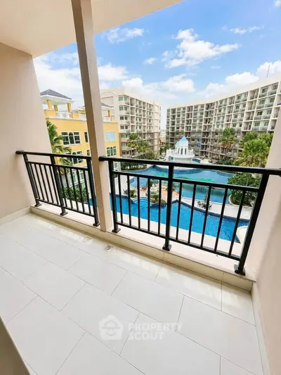 Spacious balcony with stunning pool view in modern apartment complex