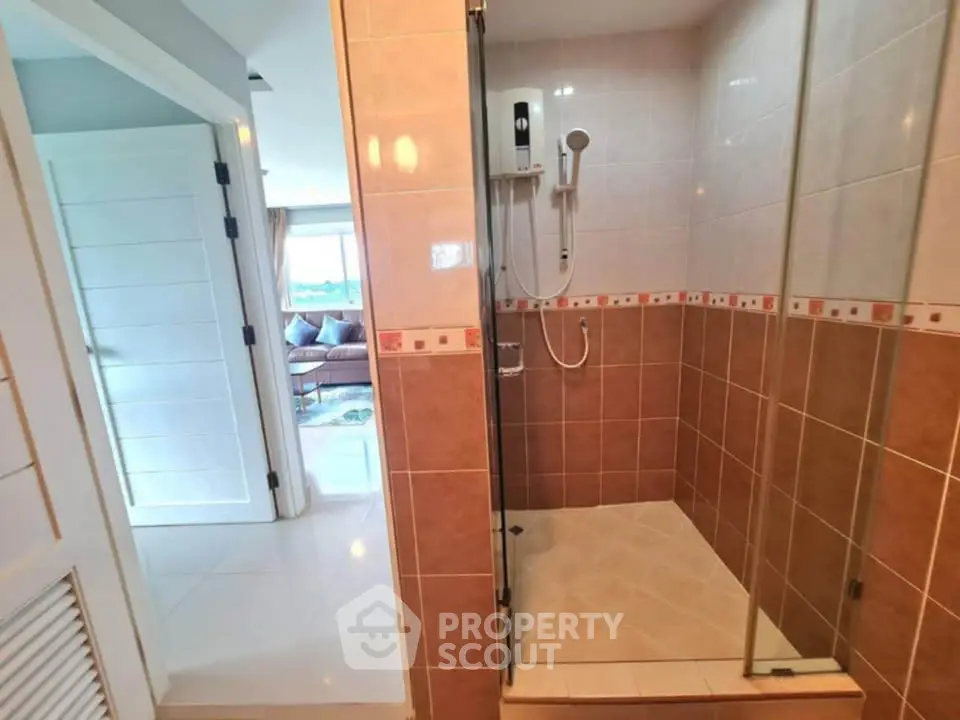Modern bathroom with glass shower and view into living room