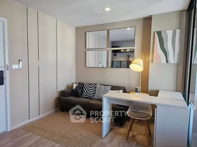 Modern living room with stylish decor, cozy sofa, and sleek desk in a contemporary apartment.