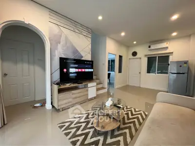 Modern living room with sleek furniture and wall-mounted TV, featuring open layout and stylish decor.