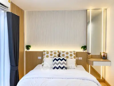 Modern bedroom with stylish decor and ambient lighting, featuring a cozy bed and elegant wall design.