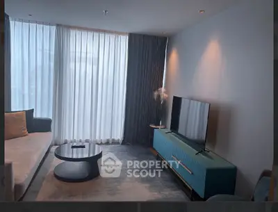 Modern living room with stylish furniture and large window, perfect for relaxation and entertainment.