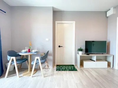 Modern living room with stylish dining area and TV setup, featuring sleek furniture and elegant decor.