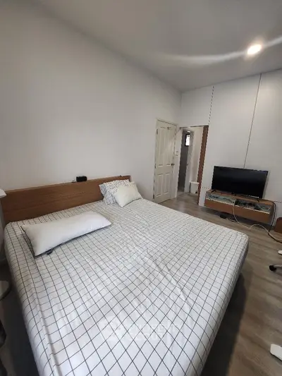 Spacious bedroom with large bed, modern flooring, ample lighting, and a flat-screen TV, perfect for relaxation and comfort.