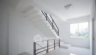 Modern minimalist staircase with large window and natural light
