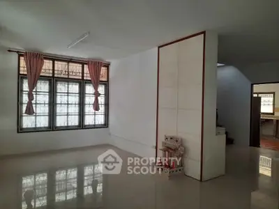 Spacious living room with large windows and tiled flooring, perfect for natural light and modern living.