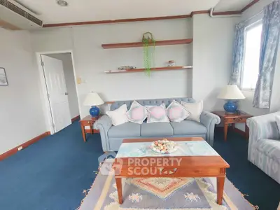 Charming living room with cozy blue sofa, elegant wooden coffee table, and decorative shelves in a bright, airy space.