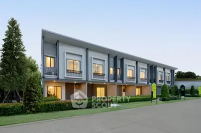 Modern townhouse exterior with lush landscaping and spacious driveway
