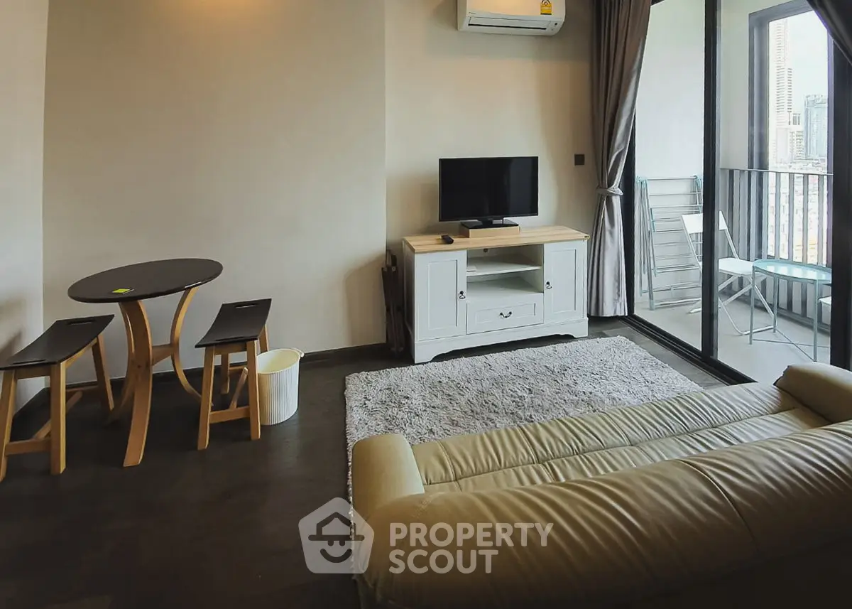 Modern living room with balcony access, featuring cozy seating and a sleek entertainment unit.