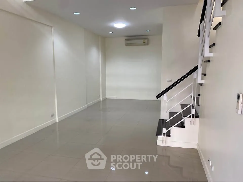 Spacious modern living room with sleek staircase and air conditioning