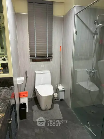 Modern bathroom with sleek design, featuring glass shower and stylish fixtures.