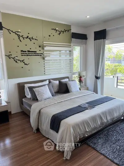 Elegant bedroom with modern decor and large windows offering natural light