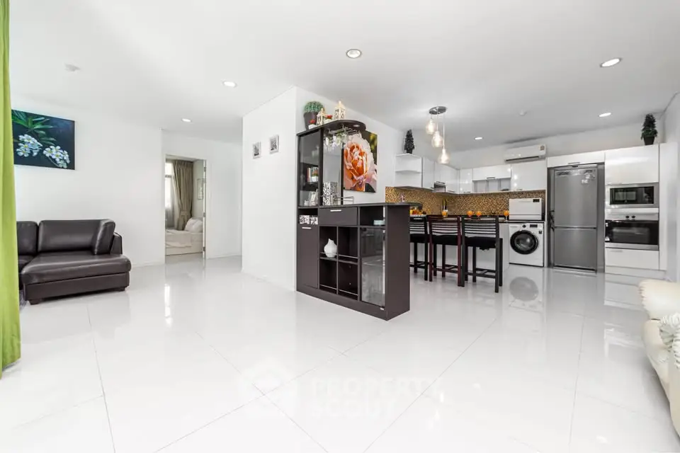 Spacious open-plan living room with modern kitchen and sleek appliances