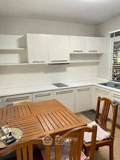 Modern kitchen with wooden dining set and sleek cabinetry