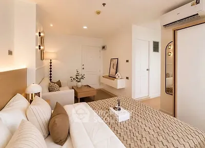 Luxurious bedroom with modern decor and cozy seating area in a stylish apartment.