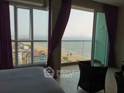 Stunning beachfront bedroom with panoramic ocean views and cozy seating area.